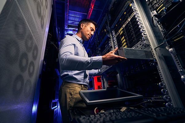 IT engineer installing a server unit in a data center rack