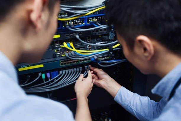 Technicians working on a network server rack